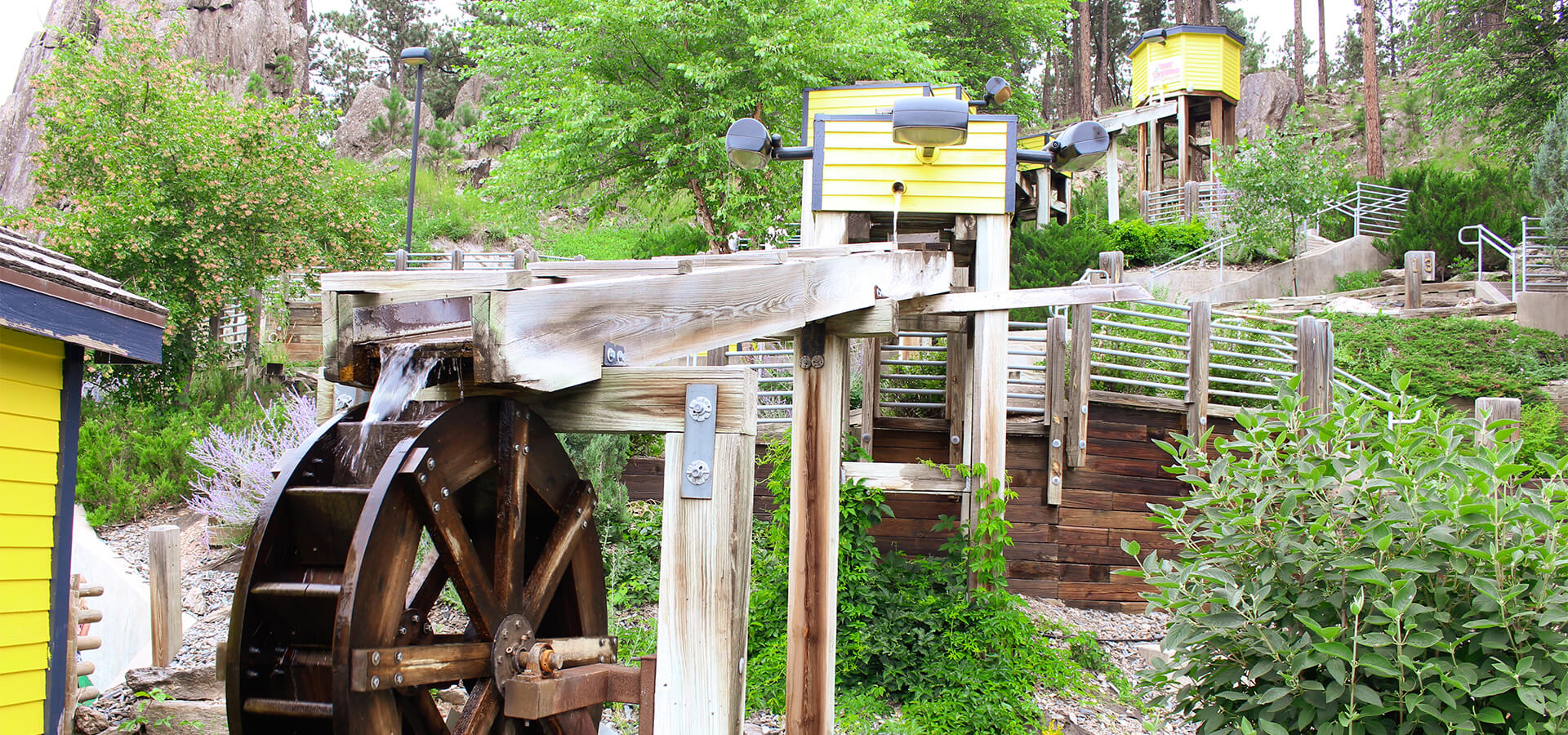 Exterior photo of water tower and the water way leading to a close up of the water wheel.